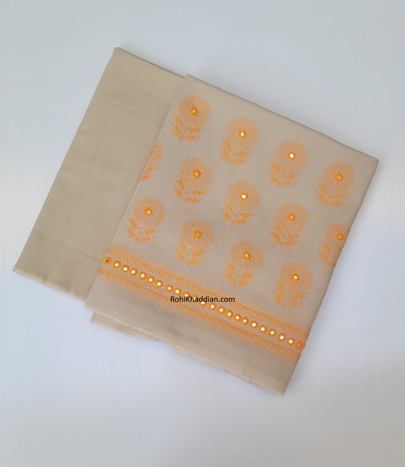 Almond beige pure cotton khaddar suit with golden orange hand embroidery and decorative border by Rohi Ki Khaddian Pakistan.