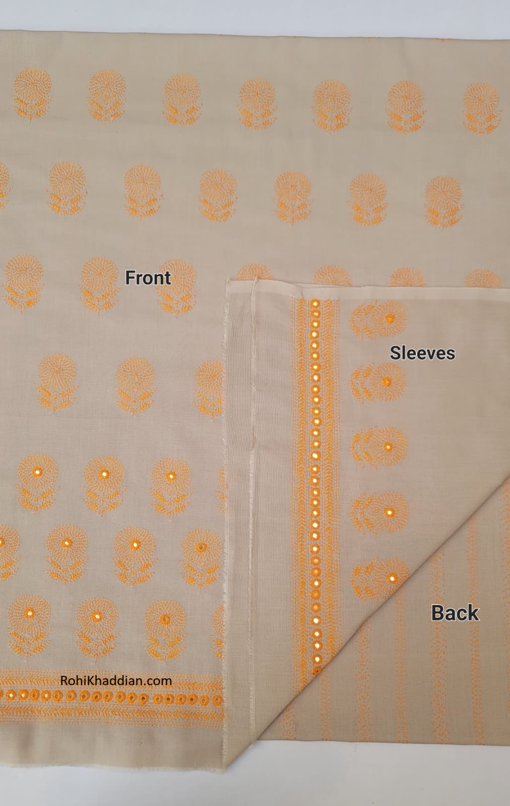 Close up of golden orange circular floral embroidery and decorative reflective embellishments on almond beige cotton khaddar fabric.